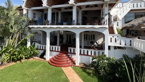 Un edificio de varios pisos con un patio central, balcones y una escalera que conduce a los niveles superiores.