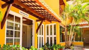 A building with a yellow facade, a wooden pergola, and a sign that reads "Sejam Bem Vindos". - Pousada Mares Sergipe (Estancia)