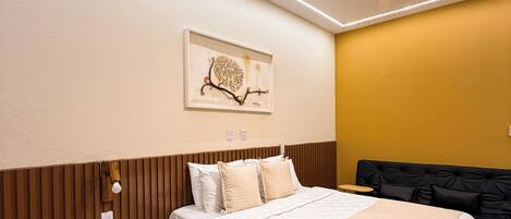 Une chambre moderne avec un lit, une table de chevet et un luminaire fixé au mur.