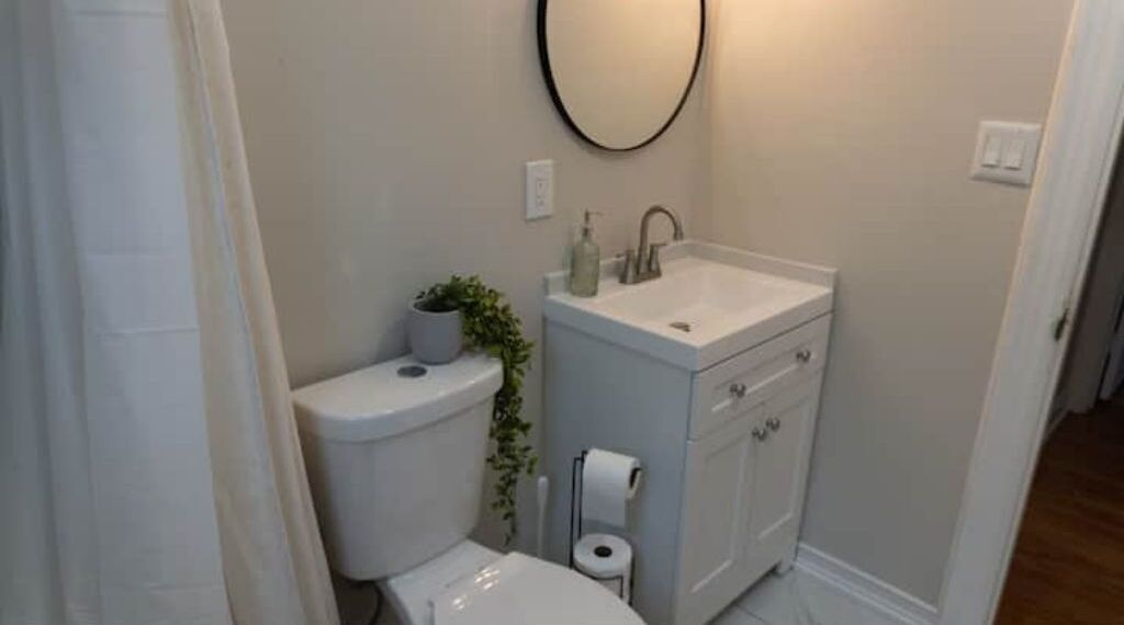 Un bagno piccolo con il water, un lavandino e uno specchio.