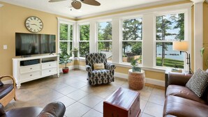 A living room with a large window, a television, a sofa, and a chair. - Lake front home, private dock, pet friendly (Appling)