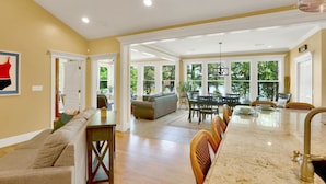 A spacious kitchen with a long island, a dining area with a table and chairs, and a living room with a sofa and a coffee table. - Lake front home, private dock, pet friendly (Appling)