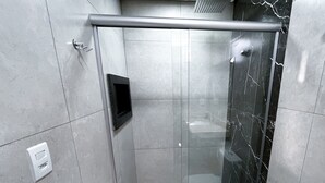 A modern bathroom with a glass-enclosed shower, a toilet, and a sink. - Planaltina (Planaltina)