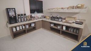 A kitchen with a coffee machine, microwave, and a variety of utensils and dishes on shelves. - Planaltina (Planaltina)