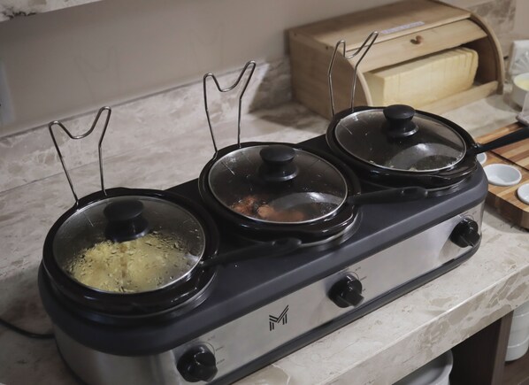 A kitchen stove with three pots on burners, a wooden cabinet in the background, and a marble countertop. - Planaltina (Planaltina)