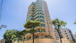 A tall, multi-story building with a zigzag pattern of balconies. - Elegante Apartamento em Enseada no Guarujá (Guarujá)