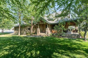 A two-story house with a stone facade, a covered porch, and a well-maintained lawn.