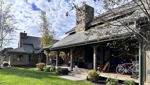 Une maison avec un porche, une cheminée et un vélo garé devant.