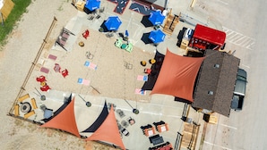 An aerial view of a parking lot with several tents, tables, and chairs arranged for an event. - Springs Lodge & Cafe (Hot Springs)