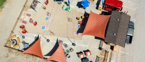 An aerial view of a parking lot with several tents, tables, and chairs arranged for an event.