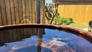Eine Holzterrasse mit Pool mit Glasboden, der Himmel und die umliegenden Bäume reflektiert.
