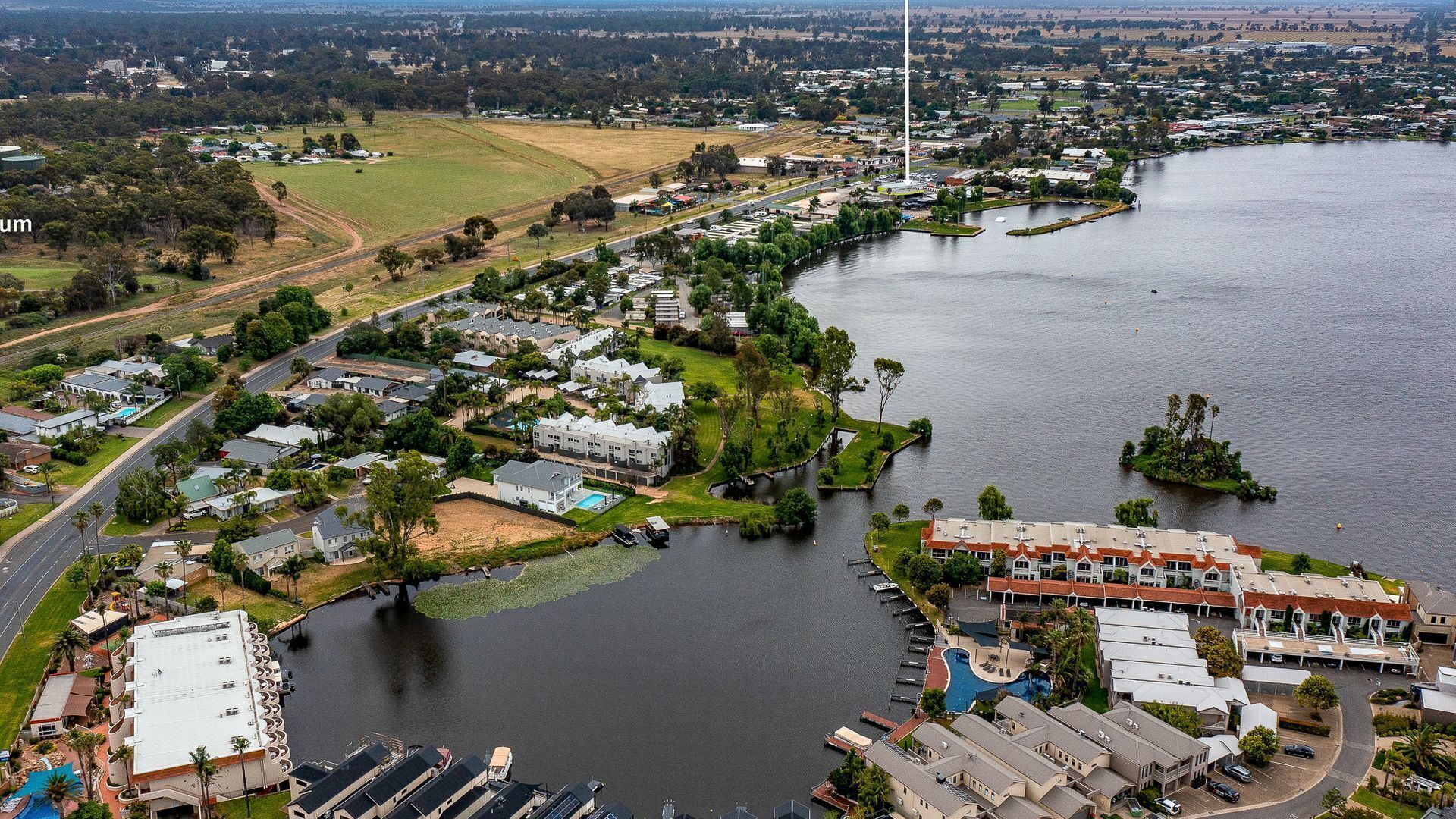 Un quartier résidentiel comprenant des maisons, un port de plaisance et une vaste étendue d’eau.
