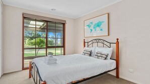 Une chambre à coucher avec un lit, une fenêtre et une carte du monde accrochée au mur.