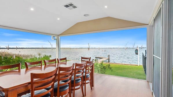 A covered outdoor dining area with a view of the water.