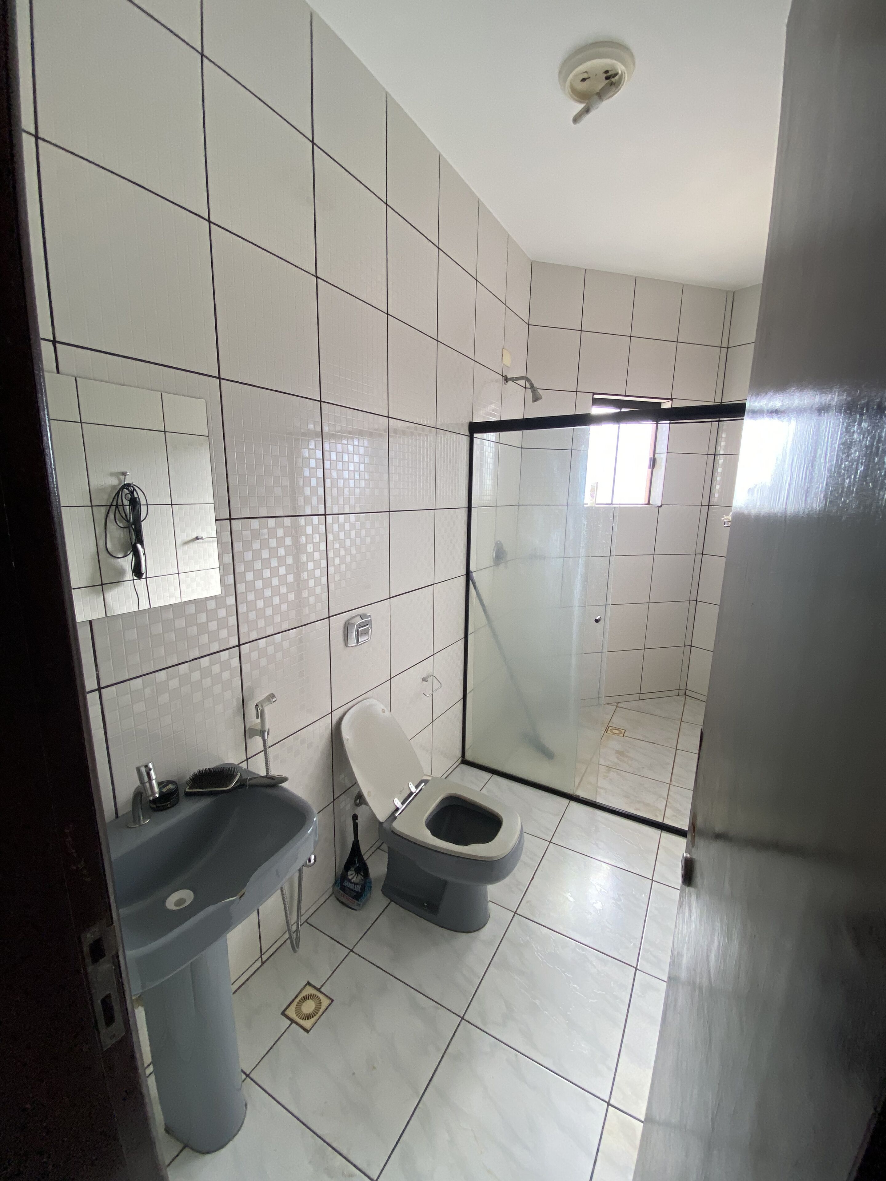 A modern bathroom with a toilet, sink, and shower.