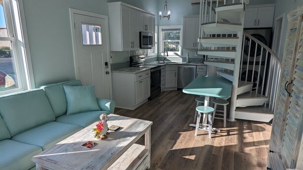 A modern kitchen with white cabinets, a black microwave, and a sink. - Coastal Cottage, walk to downtown Beaufort, close to beaches, pet friendly. (Beaufort)
