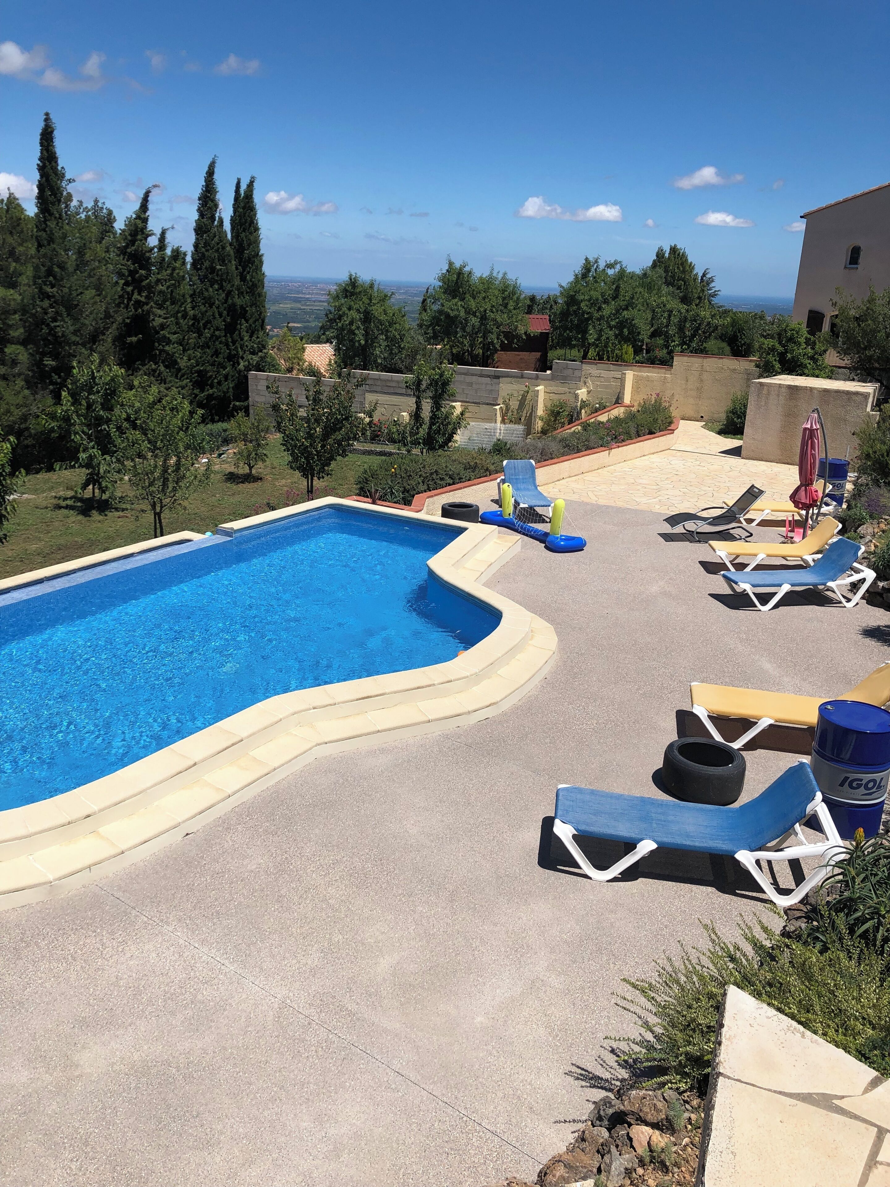 A swimming pool with lounge chairs and a view of the landscape.