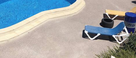 A swimming pool with lounge chairs and a view of the landscape.