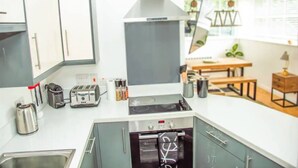 A modern kitchen with a stove, toaster, and cabinets. - 2 Double bedroom Apt in Central Bath with parking

 (Bath)
