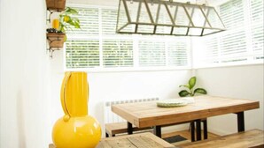 A room with a wooden table, a yellow vase, and a hanging light fixture. - 2 Double bedroom Apt in Central Bath with parking

 (Bath)