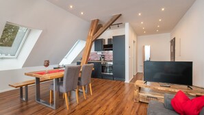 A modern loft apartment with a dining area, kitchen, and living space.