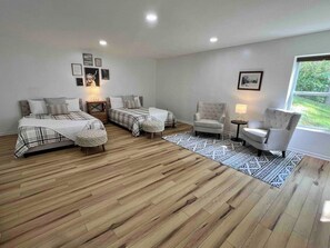 A bedroom with two beds, a chair, a small table, and a window. - Mtn View, Fire Pit+Grill, WiFi! Nearby Town & AVL! (Burnsville)