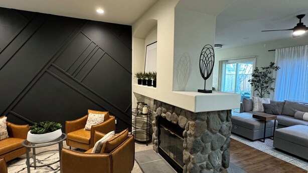 A modern living room with a stone fireplace, a sofa set, and a dining area with a round table. - Modern 4b 2bth Roseville Retreat with a spa Near Thunder Valley + The Grounds (Roseville)