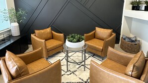 A modern living room with a geometric black wall, leather armchairs, a round coffee table, and a white rug. - Modern 4b 2bth Roseville Retreat with a spa Near Thunder Valley + The Grounds (Roseville)