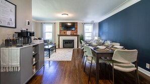 A dining area with a fireplace, a coffee station, and a view of the outdoors.
