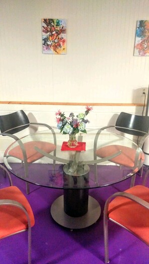 A round glass table with a vase of flowers in the center, surrounded by four chairs. - Atlanta/Stone Mountain, fenced yard, washer&dryer, Wi-Fi (Stone Mountain)