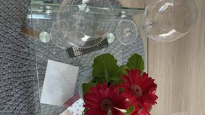 A glass table with a note, two red flowers, and several empty wine glasses. - On a golf estate with Mountain views.
4km from the Beach (Cape Town)