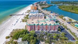 A coastal hotel with multiple buildings, a beach, and a marina.