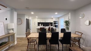Una cocina moderna con armarios blancos, una isla central y electrodomésticos integrados.
