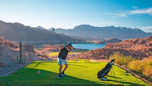 A golf course with a view of mountains and a body of water in the background. - PERFECT OASIS with private beach, golf course, kayaking, snorkeling +more (Loreto)