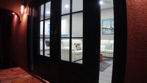A room with a white sofa, a small table, and a painting of sailboats on the wall. - 2BR Modern Golden Pear Villa, Pool, Wi-Fi, Kitchen, Views – Family/Group Ready (Saint David)