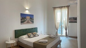 A bedroom with a bed, a round side table, a headboard, and a painting on the wall. - 3 Bedroom Apartment in Palermo (Palermo)