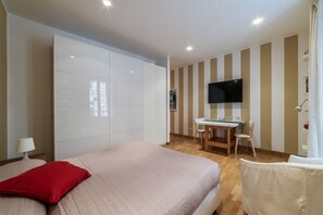 Ein Schlafzimmer mit einem Bett, einem Schreibtisch und einem Fernseher.