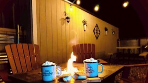 A wooden table with two blue mugs, a lit fire, and a wall with a geometric decoration. - Brand New! Restoration Retreat (Flagstaff)