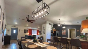 A dining area with a dark wooden table, multiple chairs, and a ceiling fan. - Brand New! Restoration Retreat (Flagstaff)