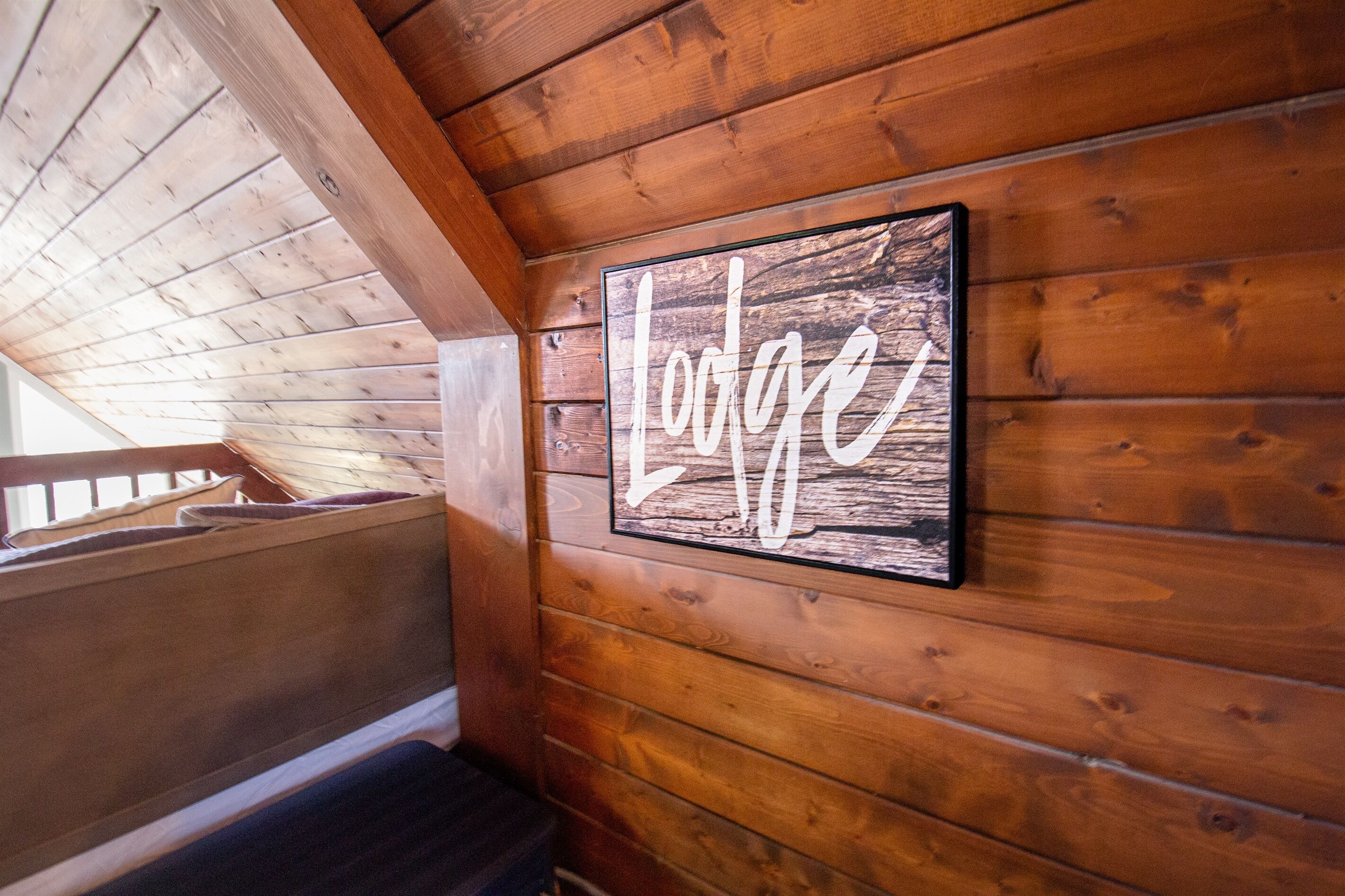 A wooden interior with a sign reading "Lodge" on the wall.