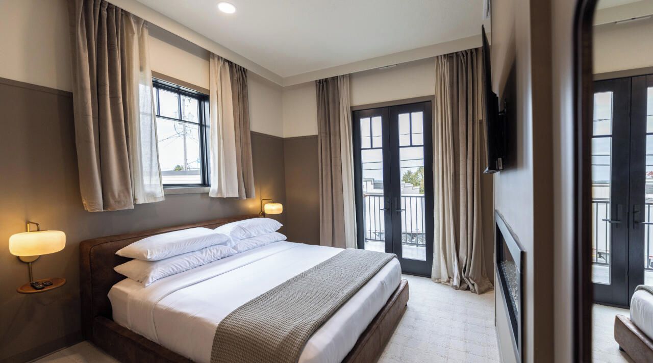 A king-size bed with a premium mattress, a two-way electric fireplace, and a wall-mounted 50" TV with streaming service included.