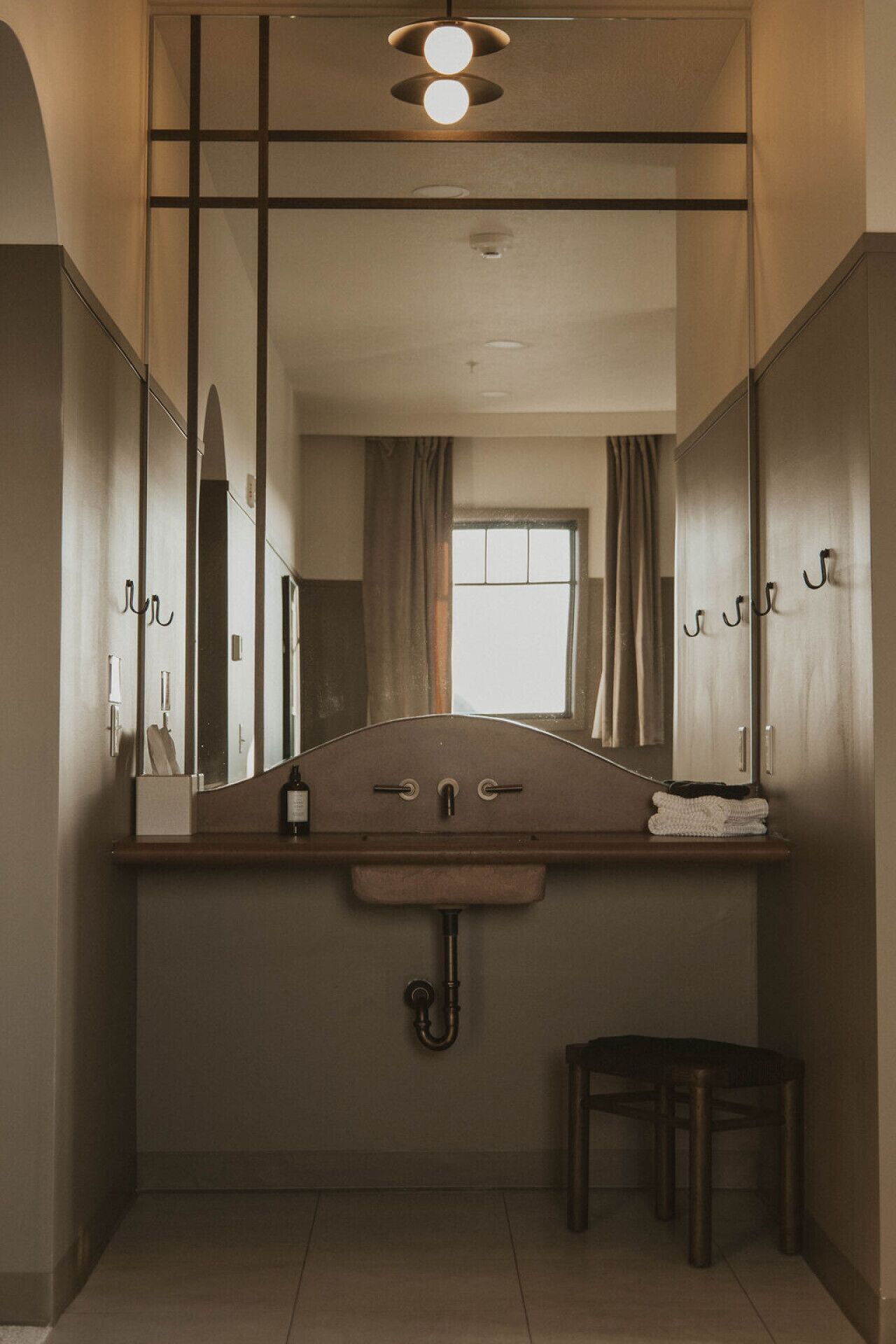 A compact bathroom with a large mirror, a sink, and a toilet.