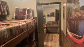 Een gezellige kamer met een bed, een bank en een deur naar een andere kamer.