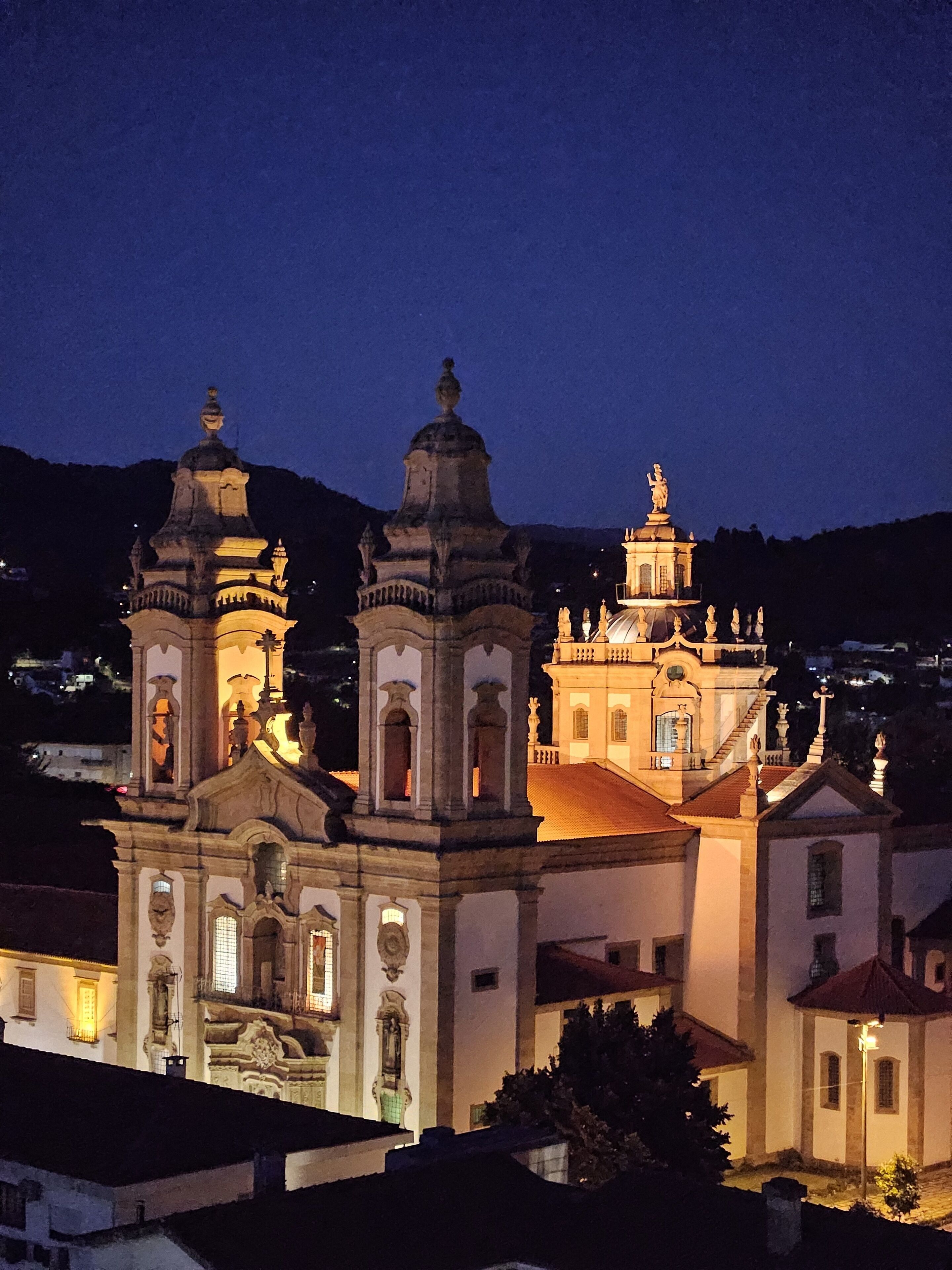 A historic church with two prominent bell towers and a central dome, surrounded by residential buildings.