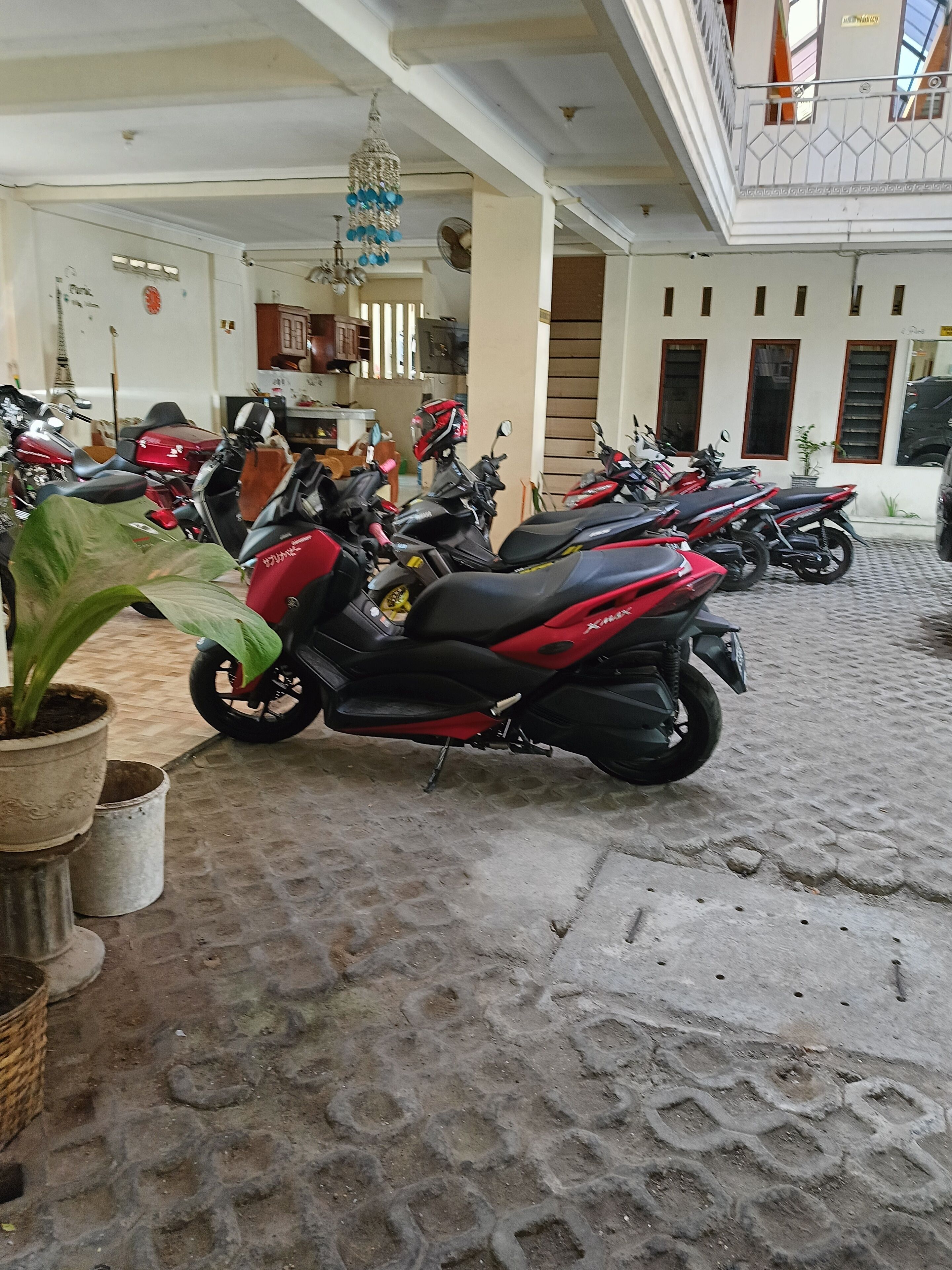 A covered parking area with multiple motorcycles parked.