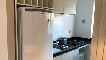 Uma cozinha moderna com geladeira de aço inoxidável, micro-ondas e fogão a gás.