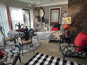 Zona pranzo con tovaglia a quadri, sedie decorate e un divano a righe zebrate.
