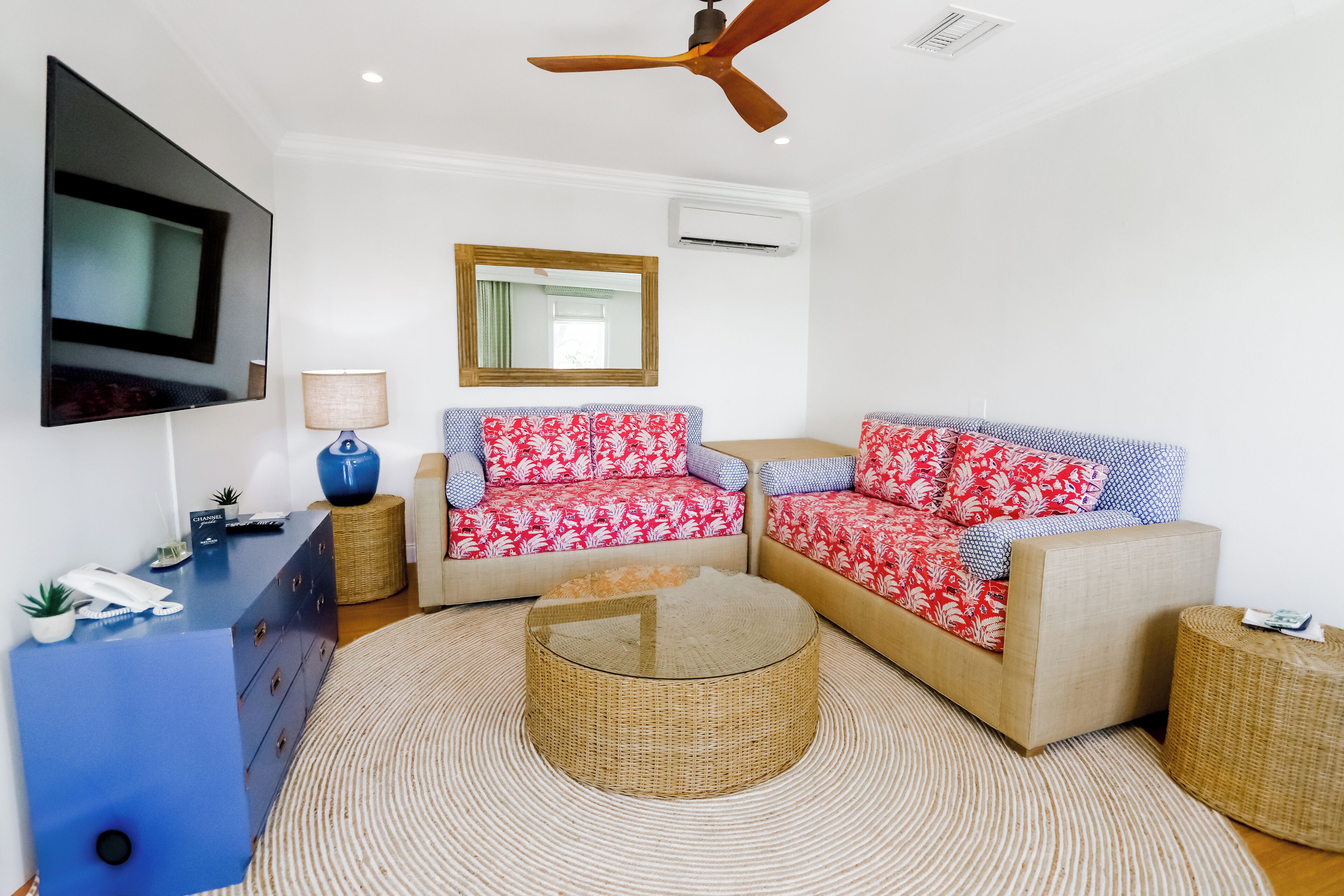 A living room with two sofas, a coffee table, a TV, and a ceiling fan.