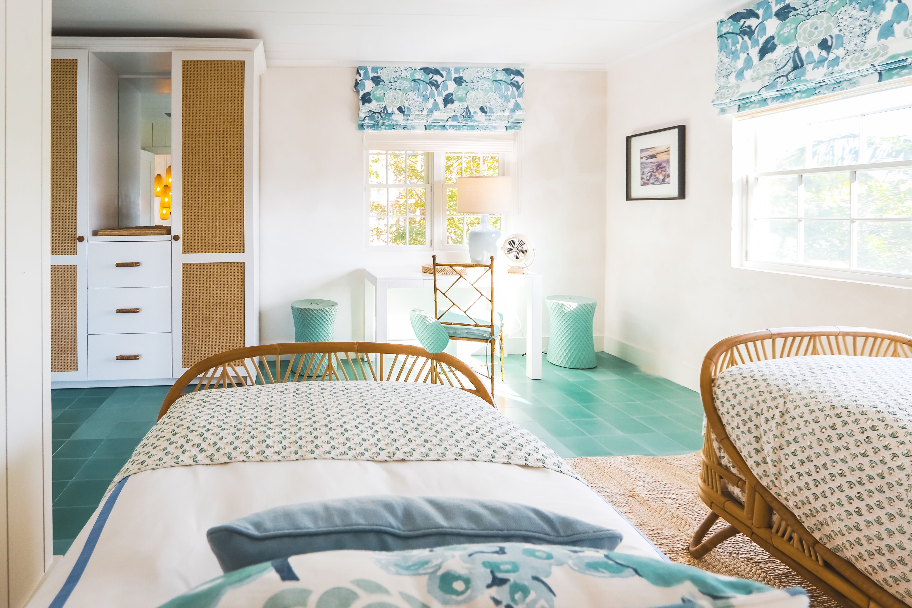 Un dormitorio con dos camas de madera, un escritorio con silla, una ventana con vistas y un armario.