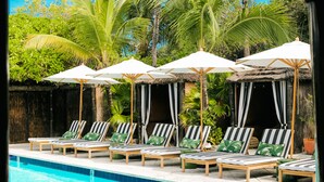 A poolside area with lounge chairs and umbrellas. - The Rock House Hotel (Dunmore Town)